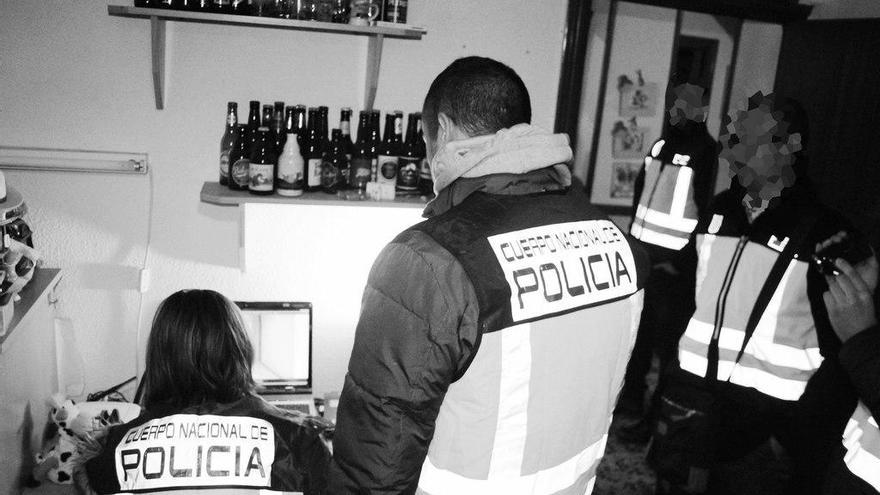 Los agentes registran el ordenador de uno de los detenidos.