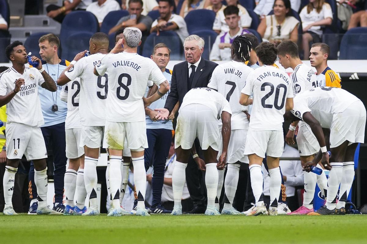 Ancelotti conversa con sus jugadores durante una pausa de hidratación.