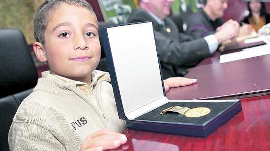 El pequeño Pedro Llera, nieto del homenajeado, muestra la medalla de oro concedida a su abuelo.