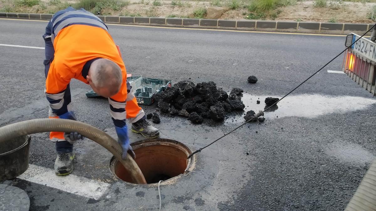 Operarios de Sercomosa retirando el hormigón que taponaba el alcantarillado y que provocó el colapso en la Avenida Ronda Este.