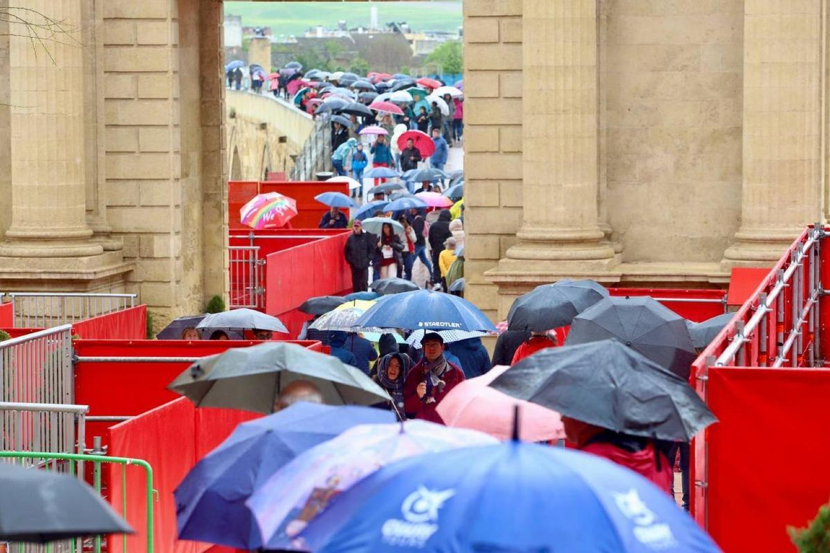 Paraguas en vez de nazarenos en la carrera oficial a su paso por la Puerta del Puente.