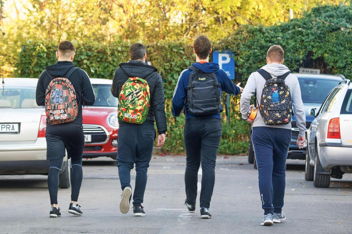 Varios estudiantes caminan hacia su coche