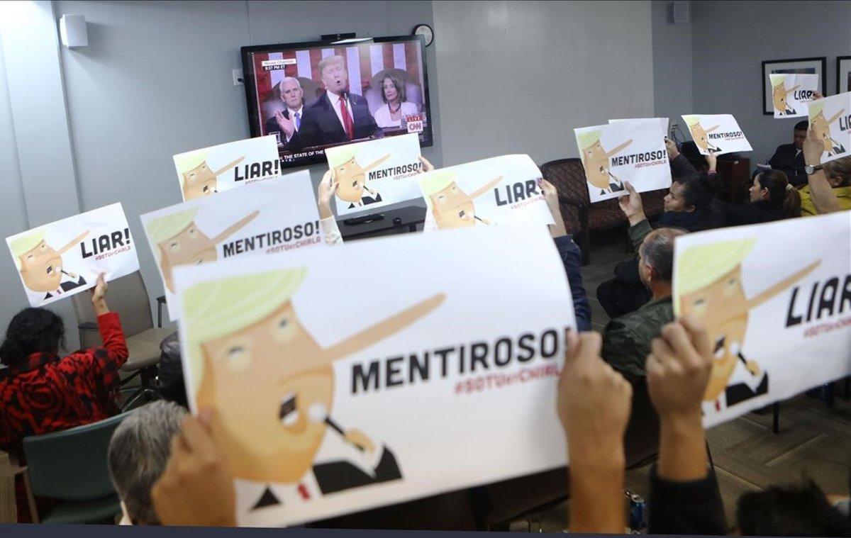 Los partidarios de los derechos de inmigración sostienen letreros contrarios a Trump.