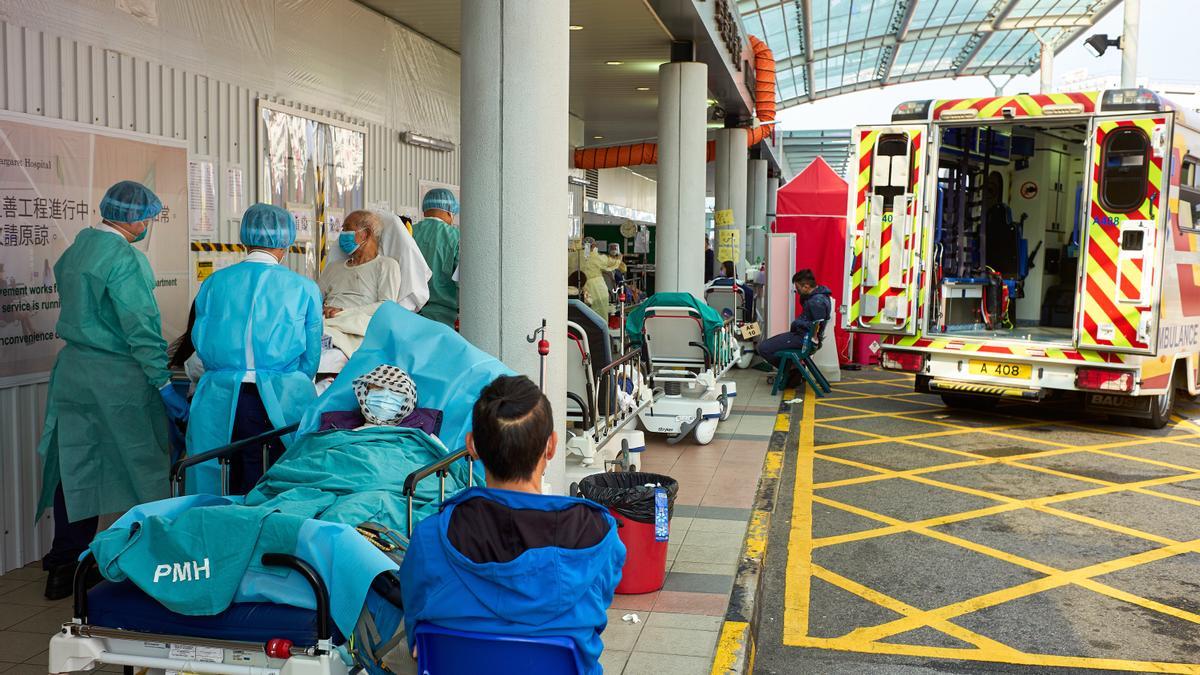 El personal del hospital transfiere pacientes de una ambulancia al departamento de emergencias del Hospital Princess Margaret en Hong Kong, ya que la ciudad enfrenta su peor brote de coronavirus en dos años.