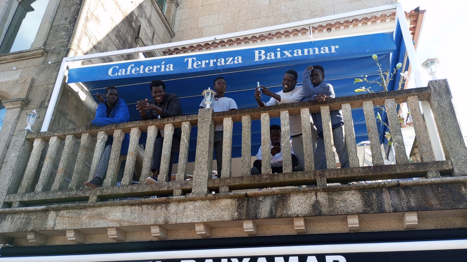 Varios de los acogidos, en una terraza del Baixamar