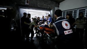 Injured people are assisted after Israeli air strike hit a hospital, according to Gaza Health Ministry