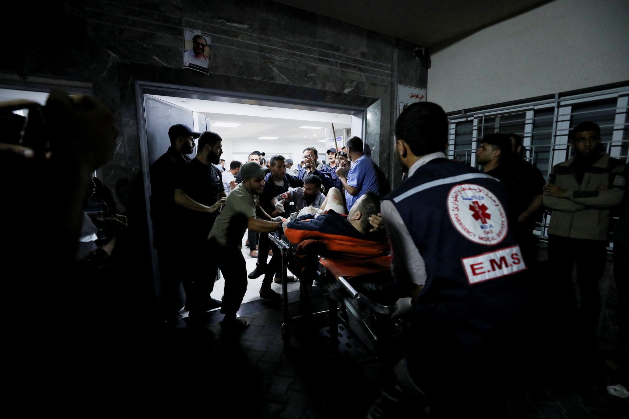 Injured people are assisted after Israeli air strike hit a hospital, according to Gaza Health Ministry