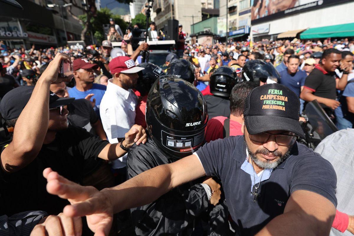 AME9811. CARACAS (VENEZUELA), 09/01/2025.- La líder antichavista María Corina Machado (c, casco negro) se retira de una manifestación este jueves, en Caracas (Venezuela). Machado anunció, a un día de la toma de posesión presidencial, el comienzo de una nueva fase del proceso para la libertad de Venezuela, y pidió a los ciudadanos estar atentos a las señales sobre los próximos pasos. EFE/ Miguel Gutiérrez