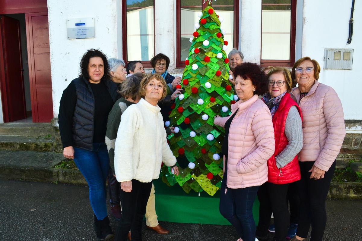 Las vecinas de Muñás, una vez colocado en el exterior de las escuelas, junto a su árbol de Navidad de ganchillo.