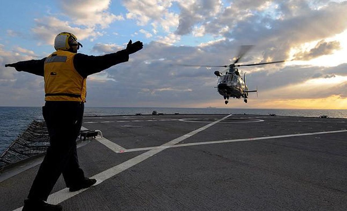 Un helicòpter de rescat francès intenta aterrar en un vaixell de la marina nord-americana al Mediterrani.