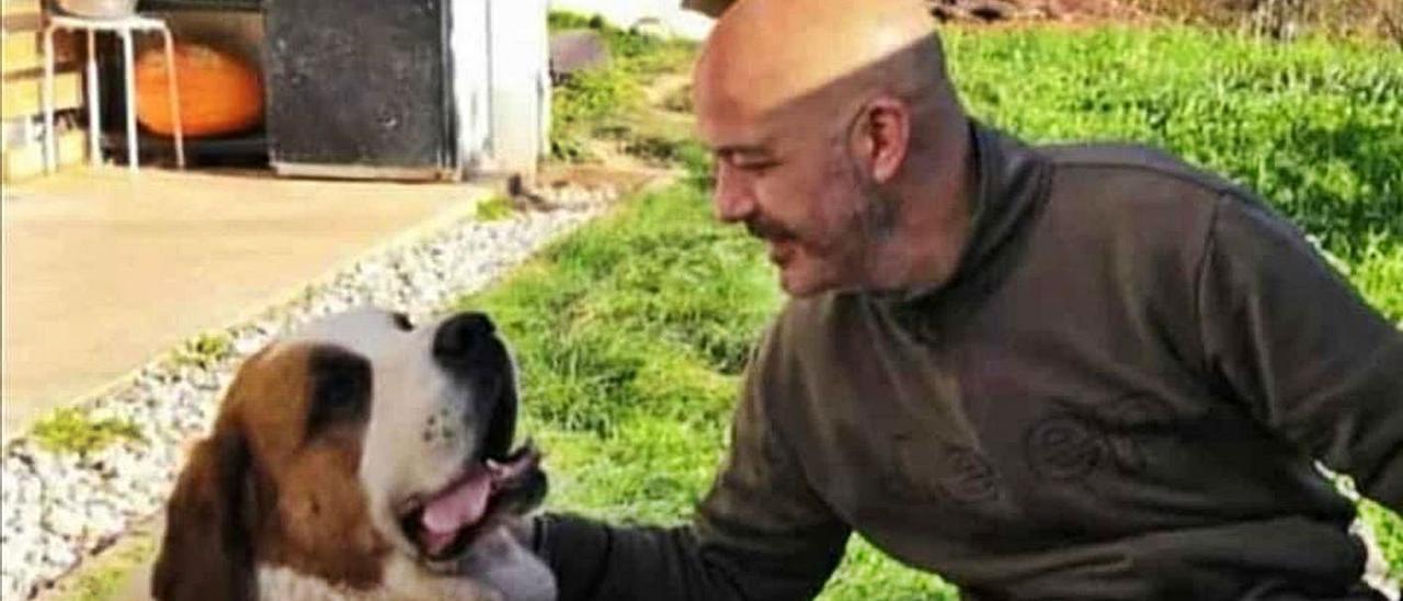 Ángel Antonio Ambrosio acaricia a un perro.