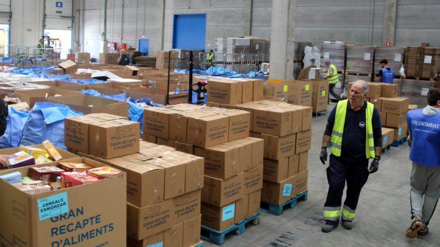 Una nau logística amb desenes de caixes plenes d'aliments del Gran Recapte.