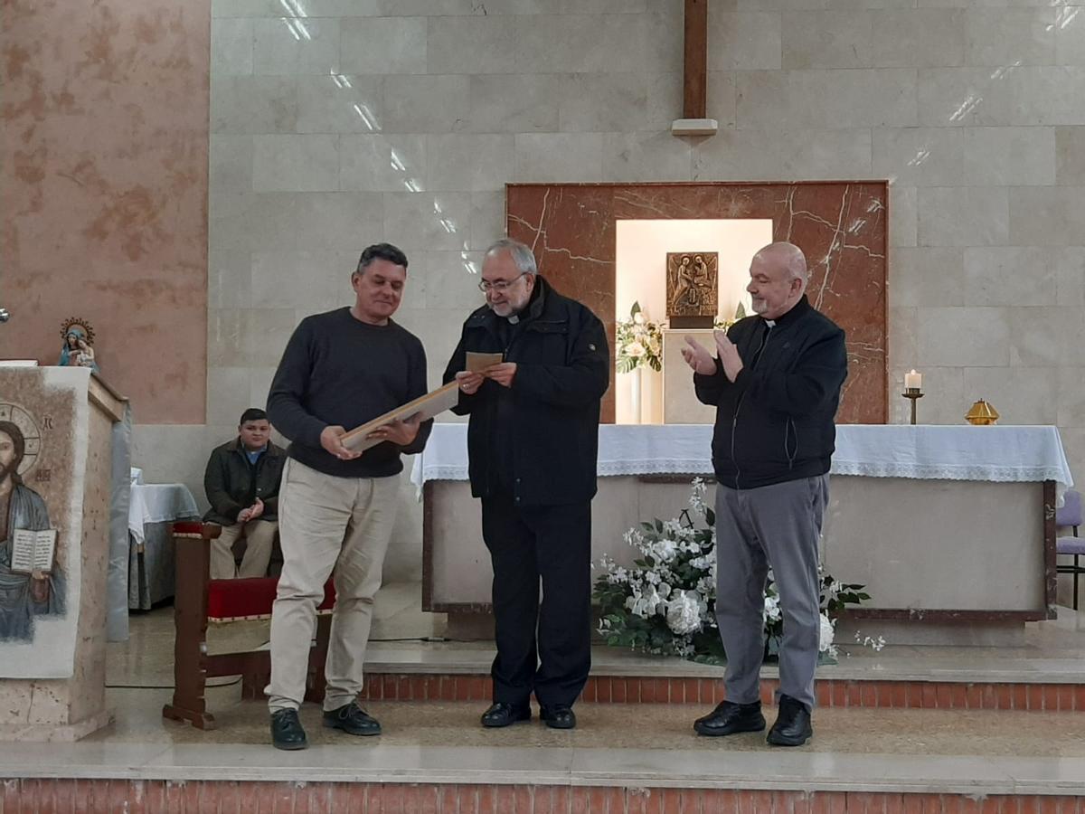 Por la izquierda, Félix García recibe el premio de manos del Arzobispo, ante la mirada de José Julio Velasco