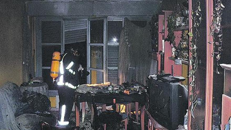 Un bombero, trabajando en el interior del salón afectado por el fuego.