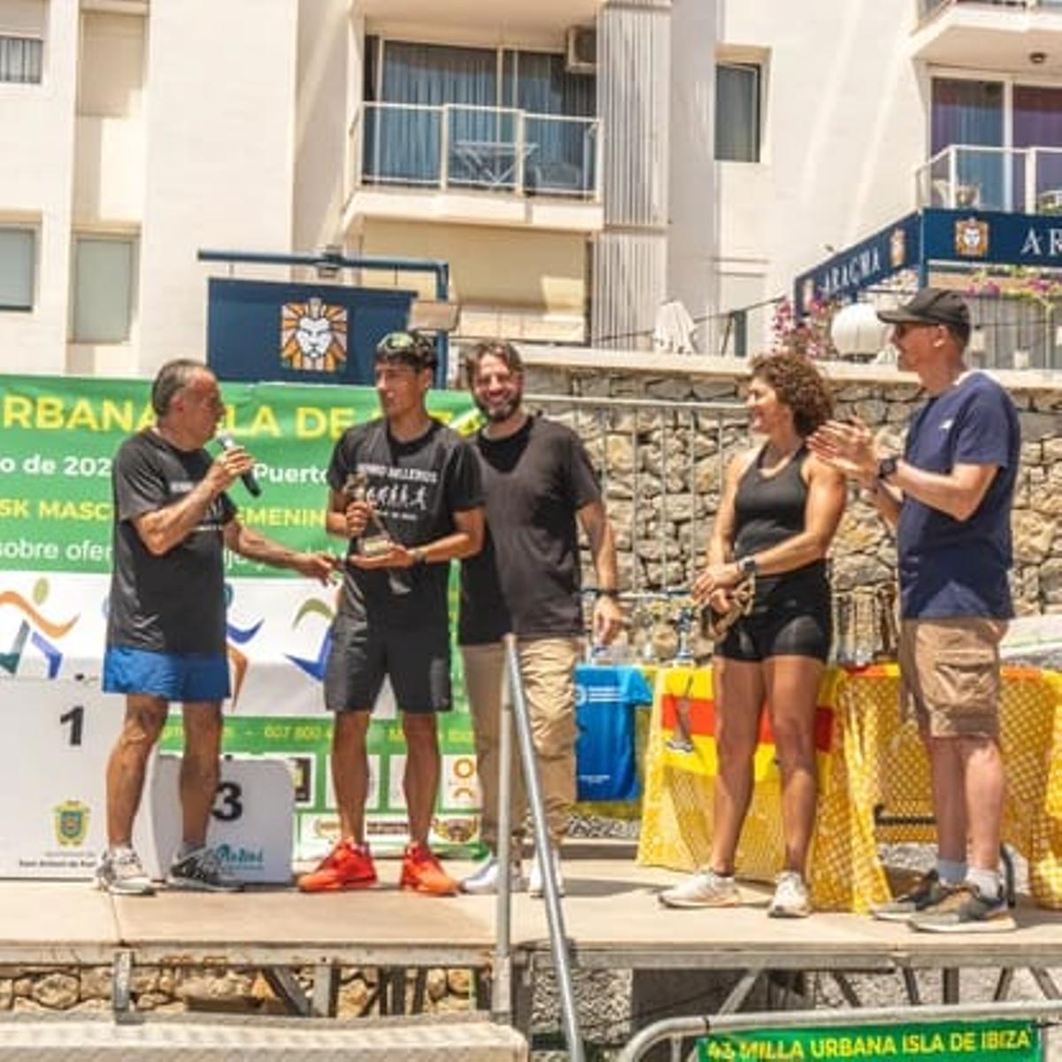 Pep Ribas entrega el Verro al hijo de Paco, Pau, en presencia del concejal de deportes de Sant Antoni, Daniel Sánchez.