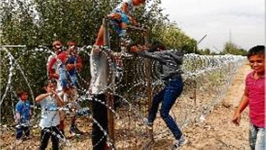 Diversos nens salten el filat de la frontera entre Sèrbia i Hongria.