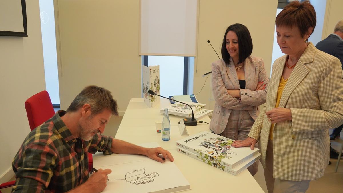 Paco Roca firma el ejemplar de la rectora Mavi Mestre y la consellera Rebeca Torró