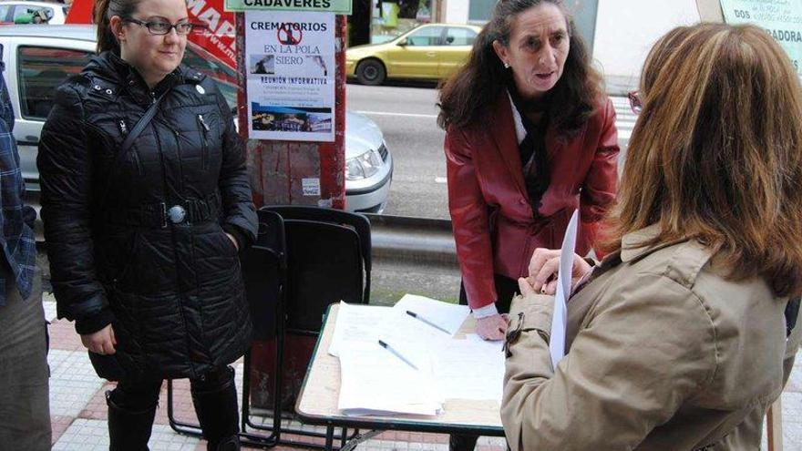 Beatriz Vale, de la AMPA del Hermanos Arregui, y Lourdes Fernández, afectada, informan a los vecinos en la mesa de recogida de firmas.