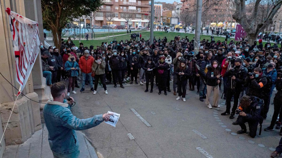 People gather outside the University of Lleida, 150 kms (90 miles) west of Barcelona, on February 15, 2021 in support of Spanish rapper Pablo Hasel after he barricaded himself inside the campus. - Hasel, who was due to begin a controversial nine-month jail sentence over a string of Tweets, barricaded himself inside the Catalan university to avoid arrest. (Photo by J. Martin / AFP)