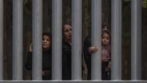 Familias migrantes de Siria e Irak son vistas detrás del muro fronterizo en la frontera entre Polonia y Bielorrusia, no lejos de Bialowieza, en el este de Polonia.