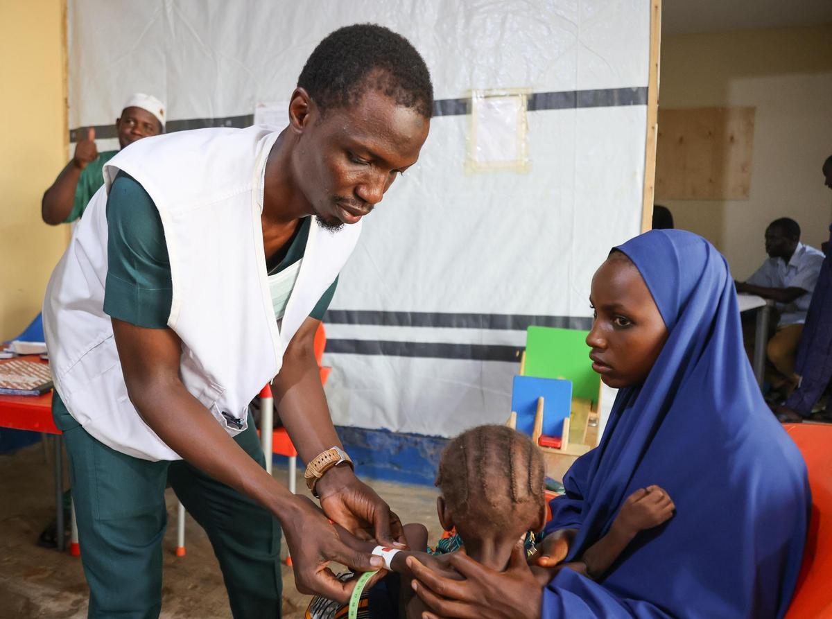 Un auxiliar de enfermería revisa a un niño en el hospital de Bauchi