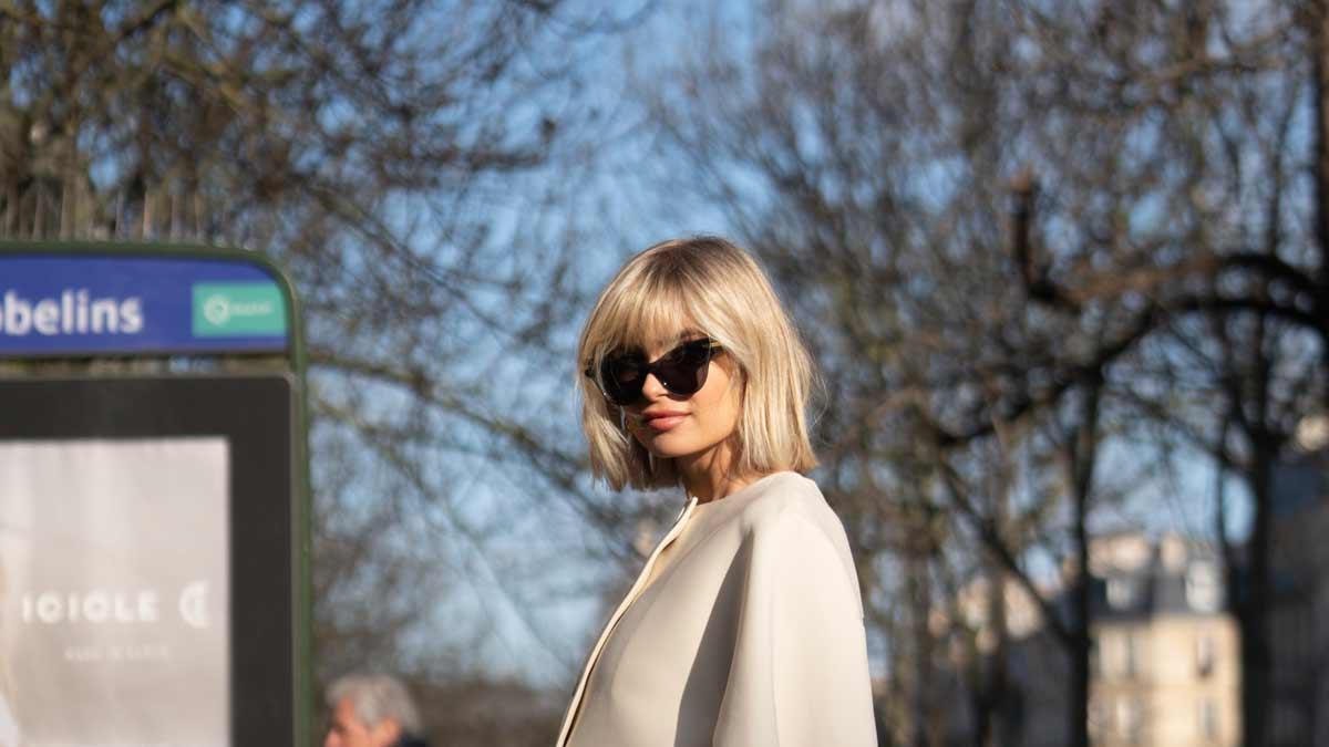 Chica con minifalda, botas altas y capa en el 'street style' de París