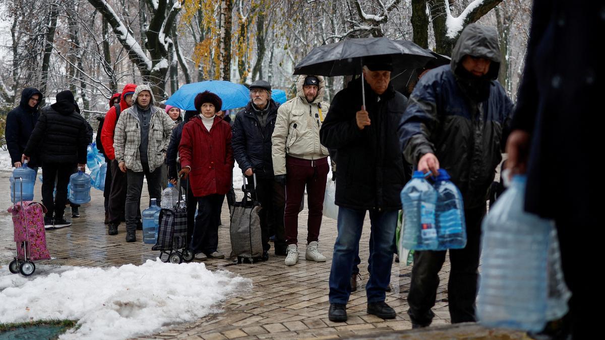 Vecinos de Kiev hacen cola para recibir agua potable en Kiev, donde los bombardeos de Rusia han causado graves problemas de suministro.