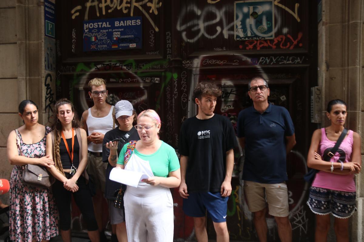 Miembros de Raval Rebel leen un manifiesto en contra de desalojo en la puerta del hostal donde vive la familia de Lela y Omar.