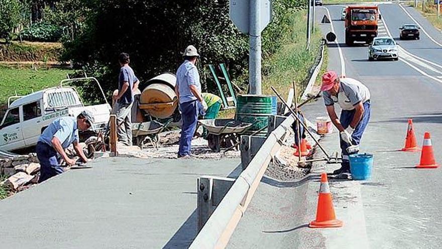 Obras de construcción de la acera en la avenida Xosé Cuiña, enfrente del centro comercial.