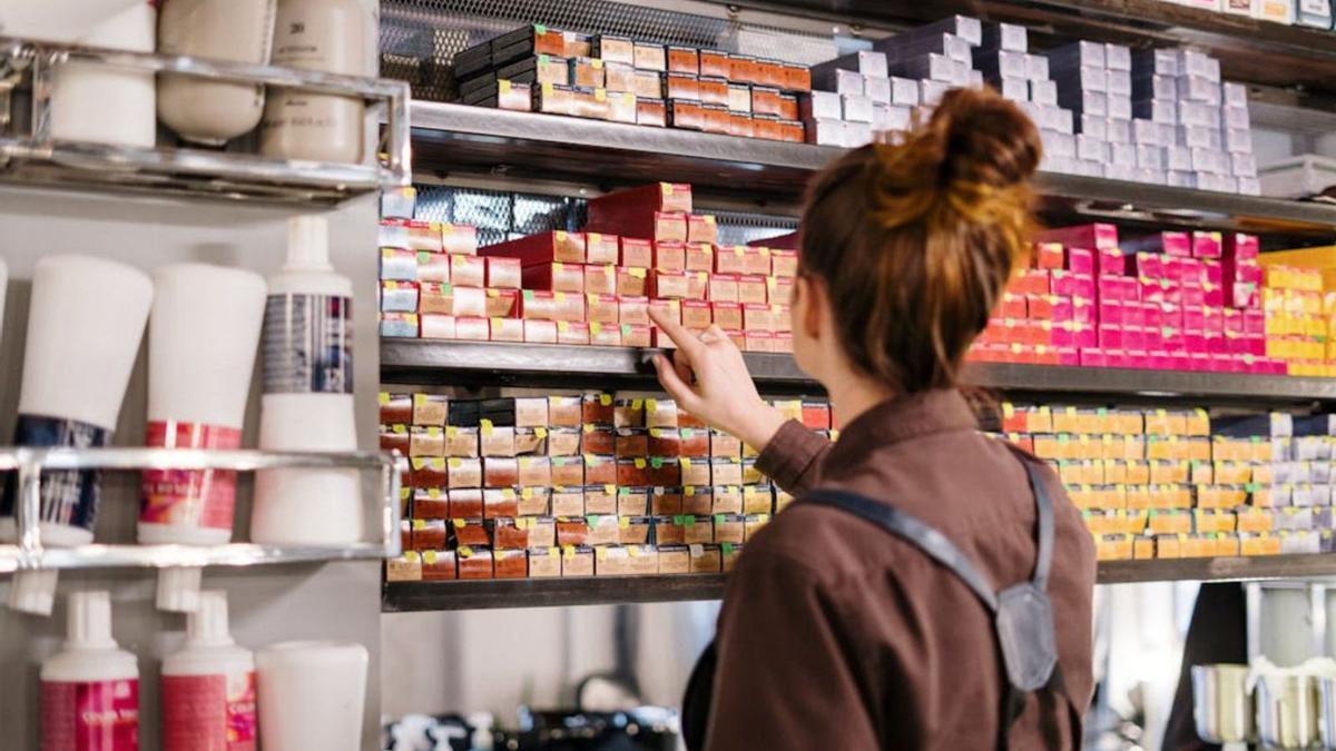 Empleada de una peluquería, ante distintos tipos de tintes.