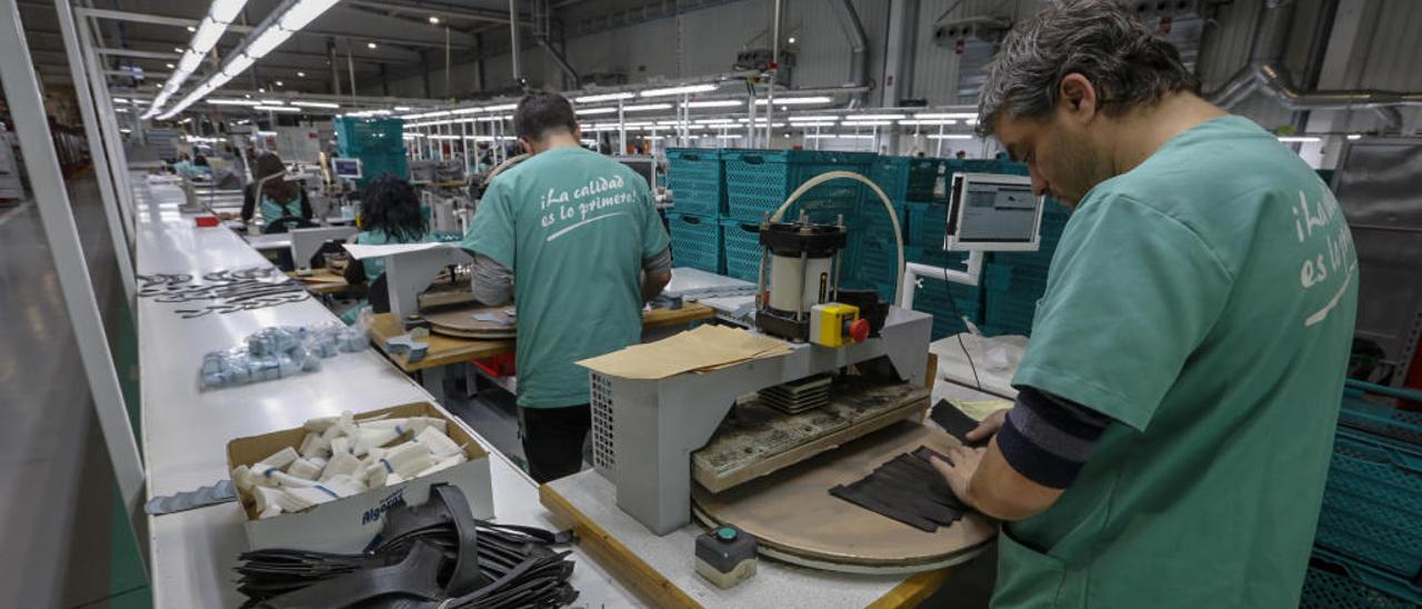 Empleados de una fábrica de calzado situada en el Elche Parque Empresarial realizan su labor durante la jornada de trabajo.