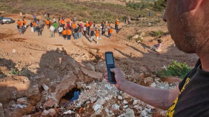 Un joven fotografía con el móvil un surco de lixiviados que llega hasta el lugar donde se reunieron ayer ecologistas y vecinos.