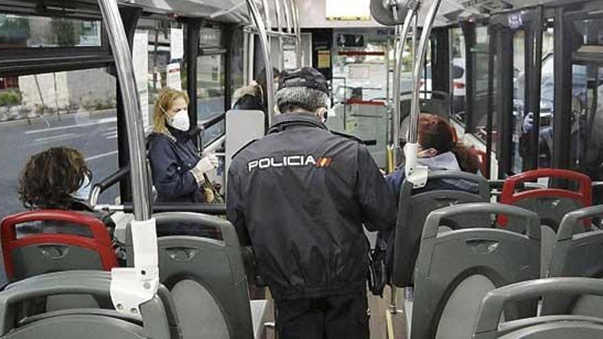 Un agente de la Policía Nacional en un autobús urbano.