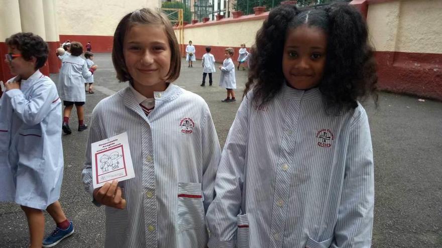 Una alumna &quot;Responsable de acogida&quot;, con una compañera, en el patio del colegio riosellano.