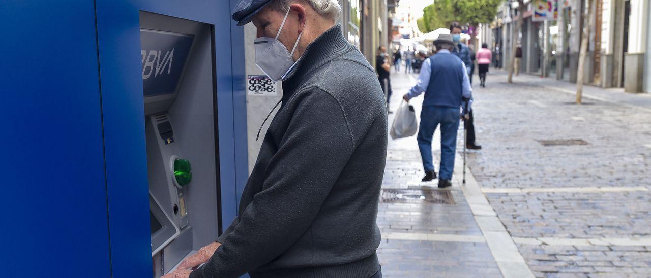 Un señor mayor realiza una operación en un cajero en la calle Domingo J. Navarro. | ANDRES CRUZ