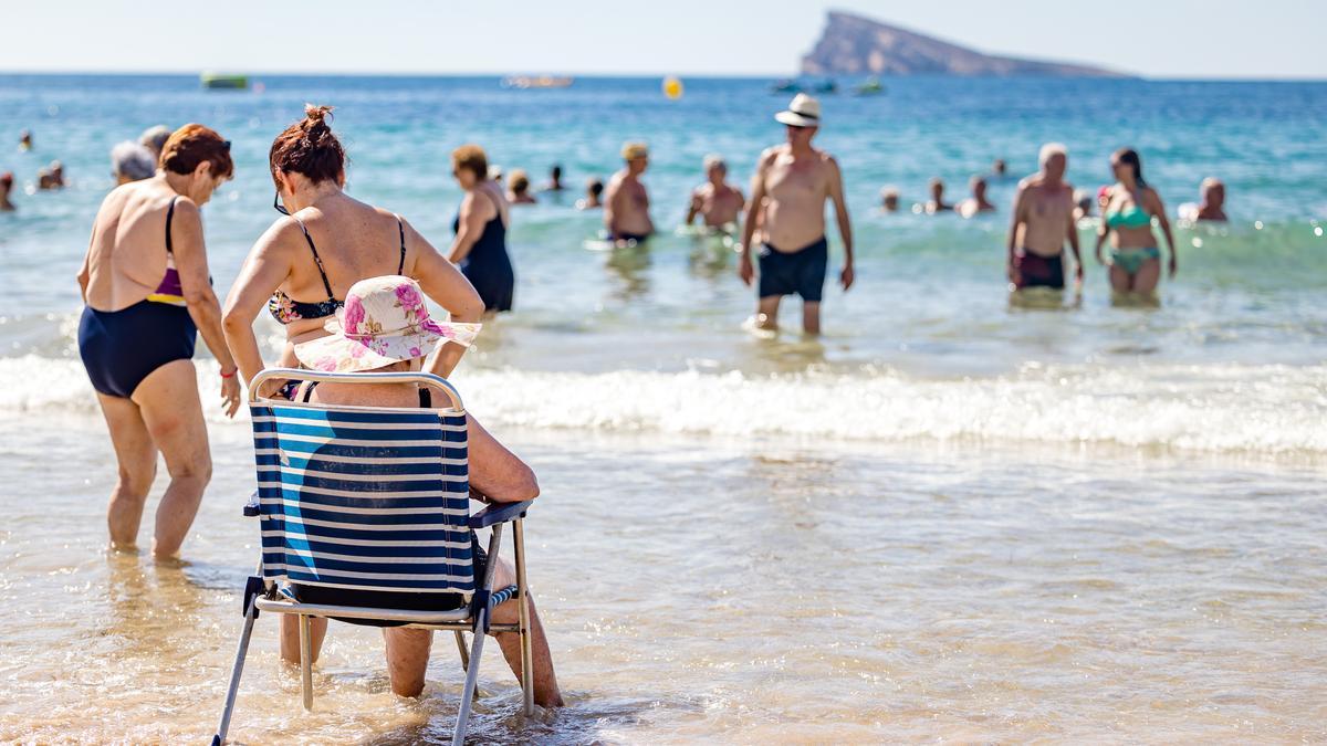 Personas mayores tomando el baño este jueves en la playa de Benidorm, uno de los destinos favoritos para los usuarios del Imserso.