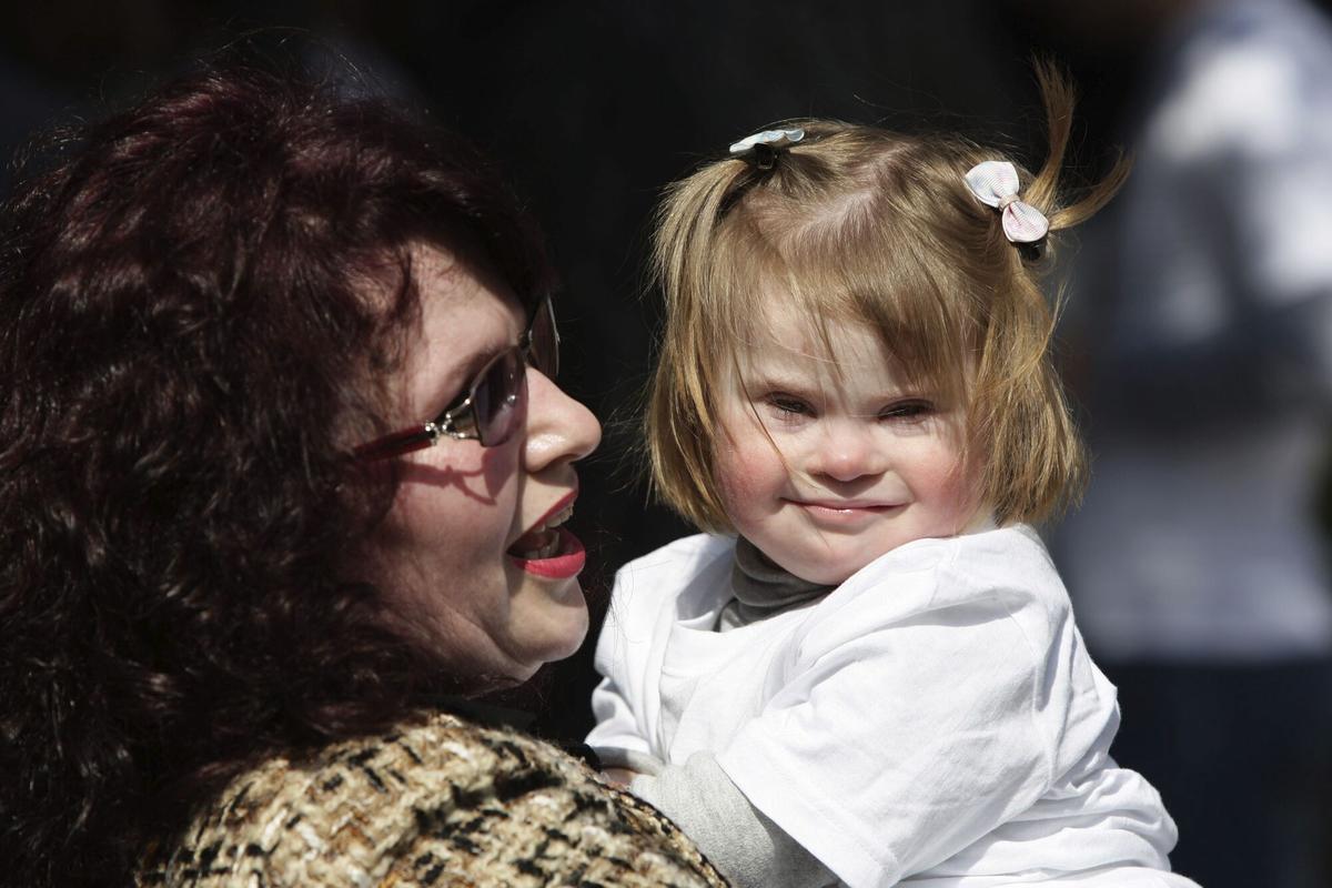 Una madre abraza a su hija con síndrome de Down