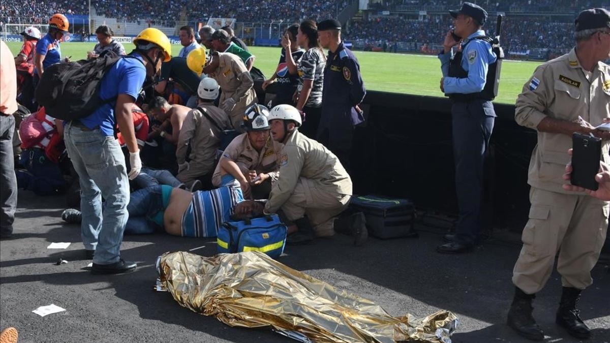 Las asistencias médicas atienden a varios heridos cerca de uno de los dos fallecidos dentro del estadio