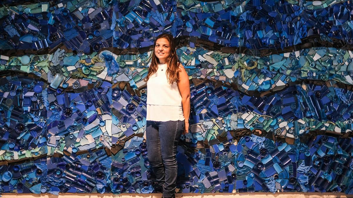La investigadora de la ULPGC, Daura Vega, ante un panel artístico creado con restos de basura marina.