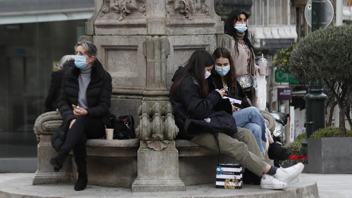 Gente con mascarilla en la farola de Urzáiz.