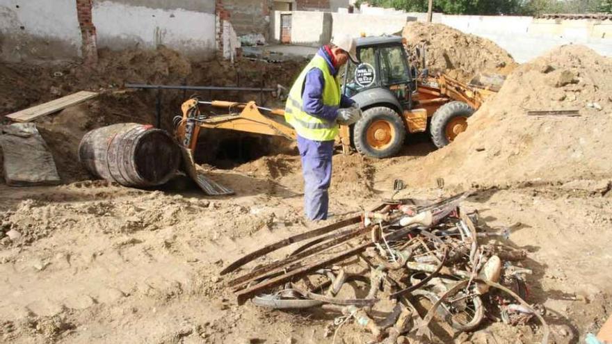 Chatarra y cubas rescatadas de una de las bodegas hundidas en el solar municipal.