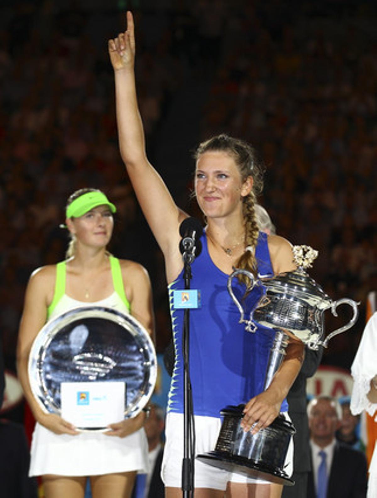 Victoria Azarenka després de rebre el trofeu que l’acredita com a guanyadora de l’Open d’Austràlia. Darrere d’ella, Maria Xarapova.