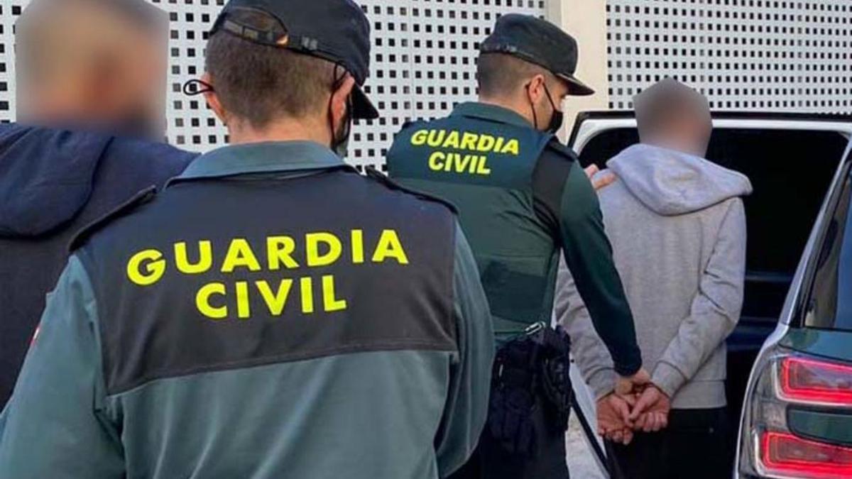 Agentes de la Guardia Civil trasladan a dos de los sospechosos detenidos. | GUARDIA CIVIL