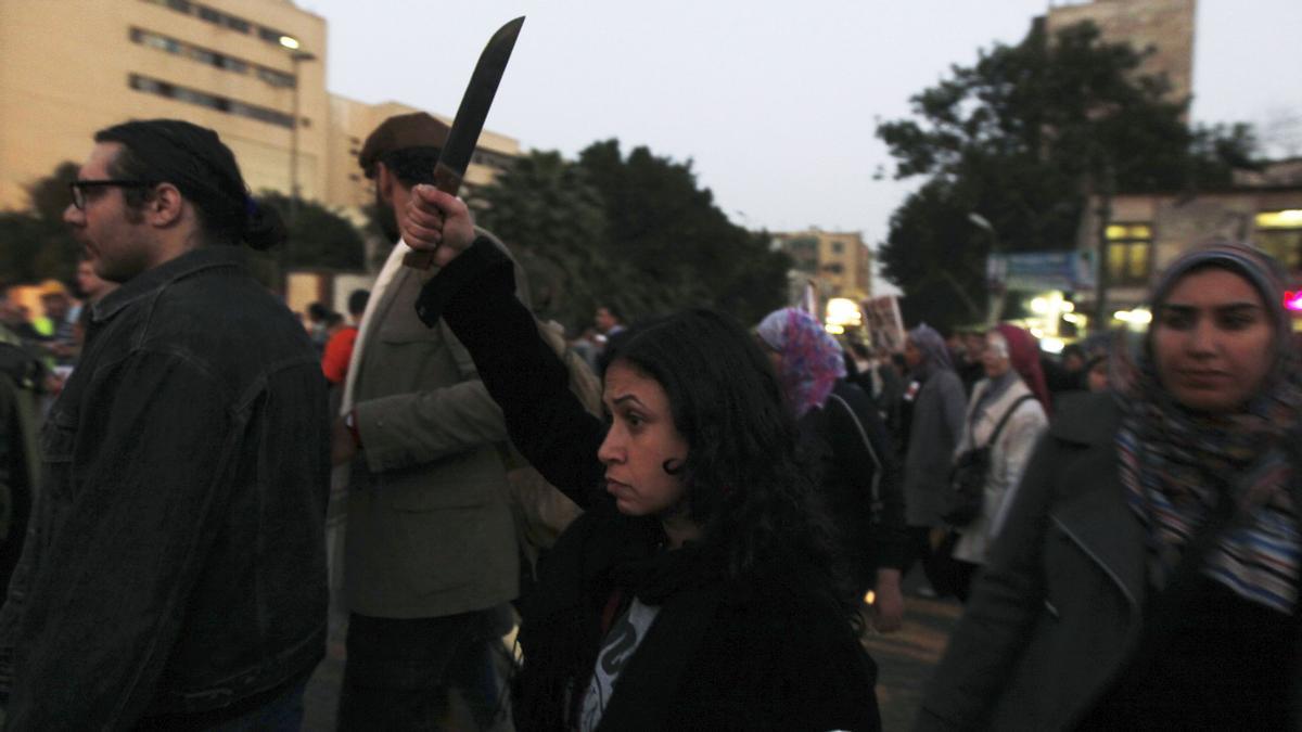 A woman raises a knife and shouts slogans against Egyptian President Mohamed Mursi and members of the Brotherhood during a march against sexual harassment and violence against women in Cairo February 6, 2013. The rally comes in response to recent cases of sexual assault in both Tahrir Square and Cairo?s Mohamed Mahmoud Street. Some anti-sexual harassment activists suspect that recent attacks ? which occurred during political demonstrations ? may have been planned in advance. REUTERS/Amr Abdallah Dalsh (EGYPT - Tags: POLITICS CIVIL UNREST)