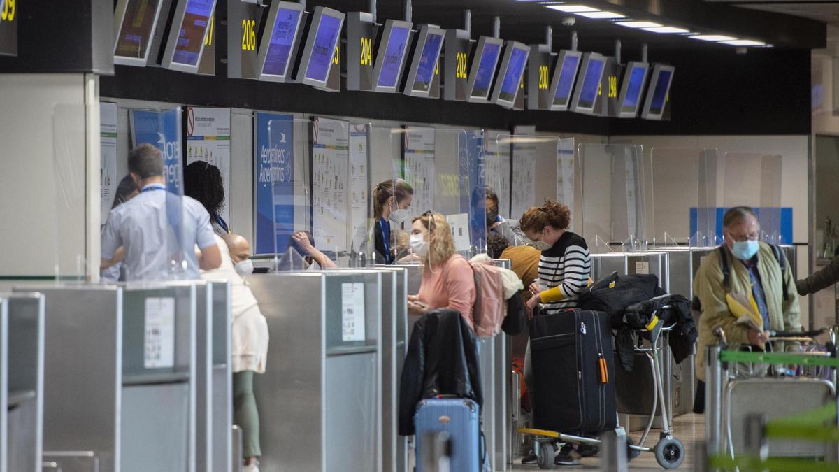 Varias personas frente a un mostrador de Aerolíneas Argentinas, en el Aeropuerto Madrid - Barajas Adolfo Suárez.