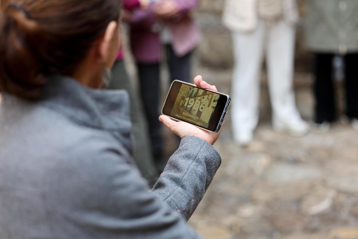 Una asistente observa un fragmento en su móvil de 'Escuadrón', de José Antonio de la Loma.
