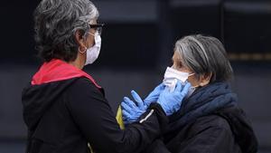 Una hija protege con una mascarilla a su madre antes de entrar al Hospital La Paz de Madrid, el 7 de abril.