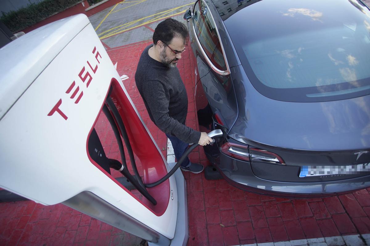 Un conductor carrega un cotxe elèctric a Girona, en una imatge d'arxiu.