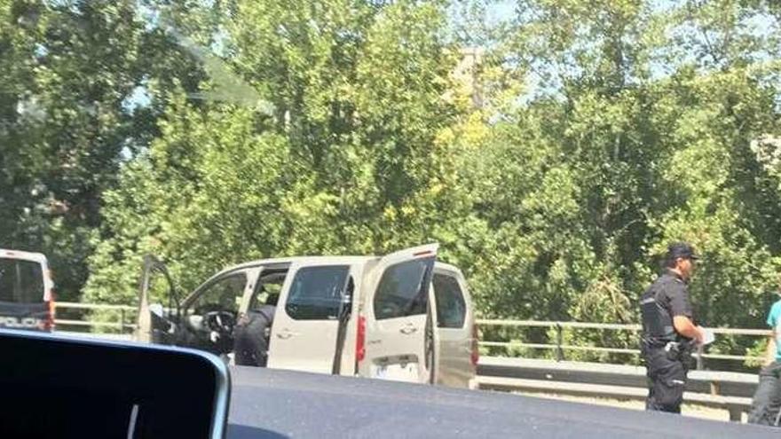 Un policía nacional inspecciona una furgoneta mientras otro habla con los ocupantes, ayer. // FdV