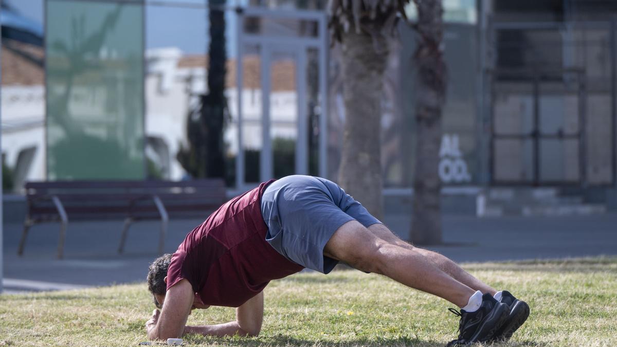 Un hombre hace deporte realizando ejercicios de estiramiento